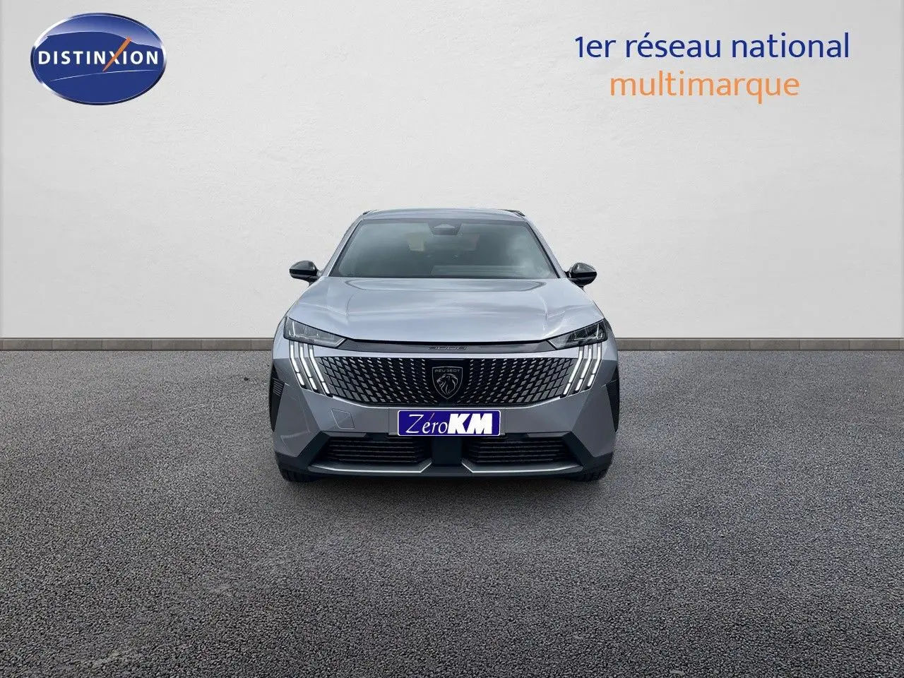 Vue frontale d'un Peugeot 5008 gris Artense métal 2025 avec calandre distinctive et feux LED verticaux allumés.