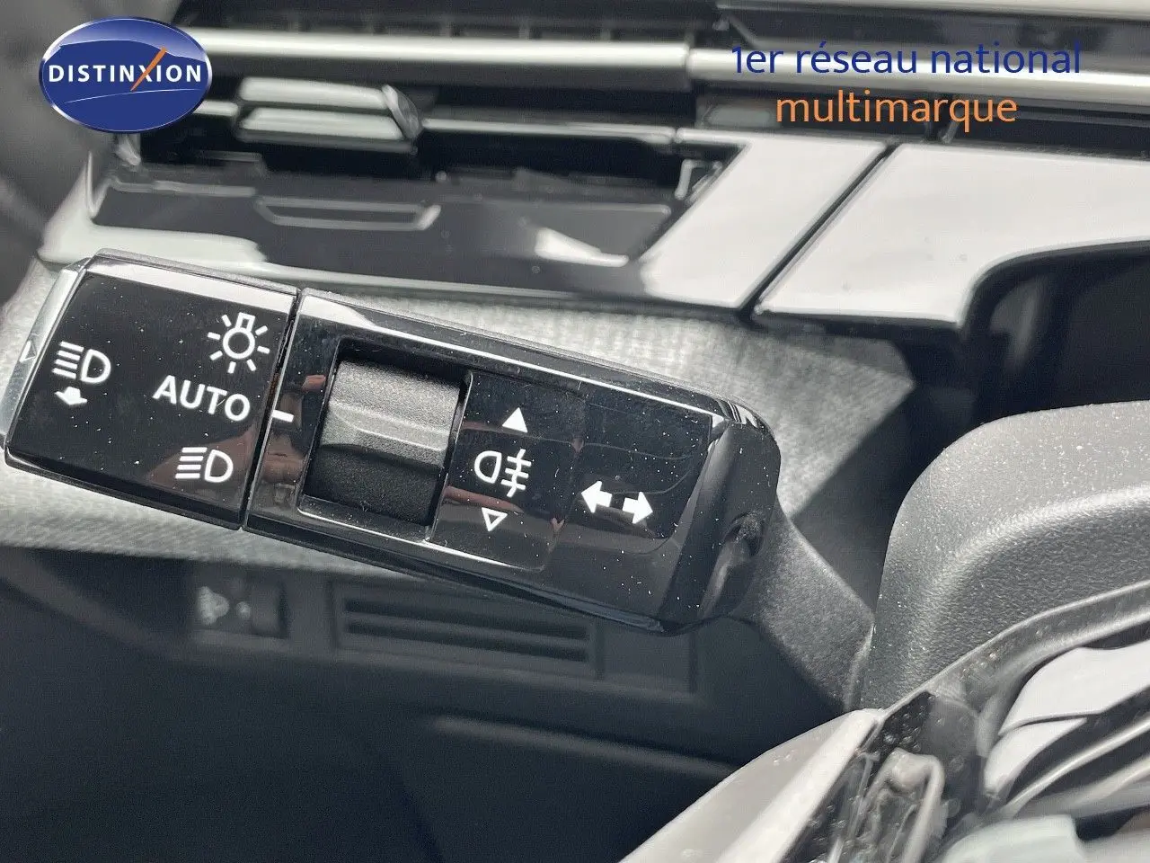 Gros plan sur la commande des feux et clignotants dans l'habitacle du Peugeot 5008 gris Artense Hybrid 2025.