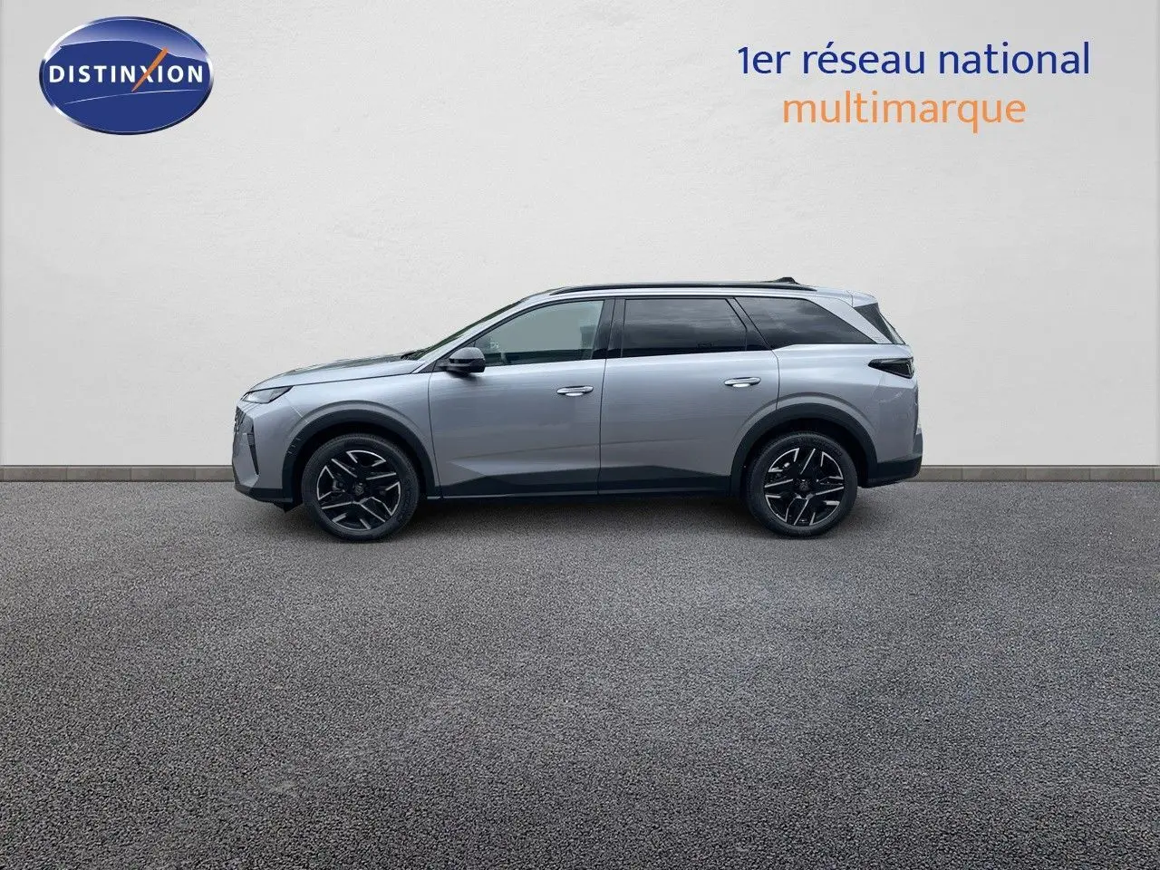 Profil côté gauche du Peugeot 5008 Hybrid gris Artense métal, soulignant ses jantes noires et lignes modernes.