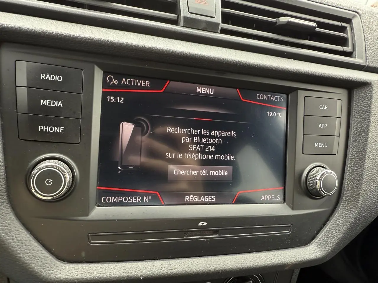 Écran tactile multimédia de la SEAT Ibiza 2019 affichant la recherche Bluetooth, entouré de boutons de commande noirs.