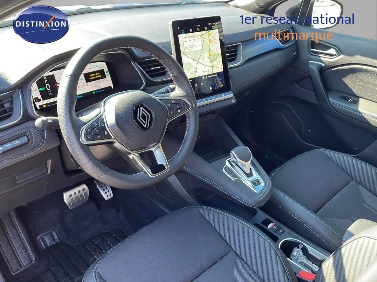 Intérieur du Renault Captur E-Tech hybride 2025, vue du poste de conduite avec écran tactile vertical et volant multifonction.