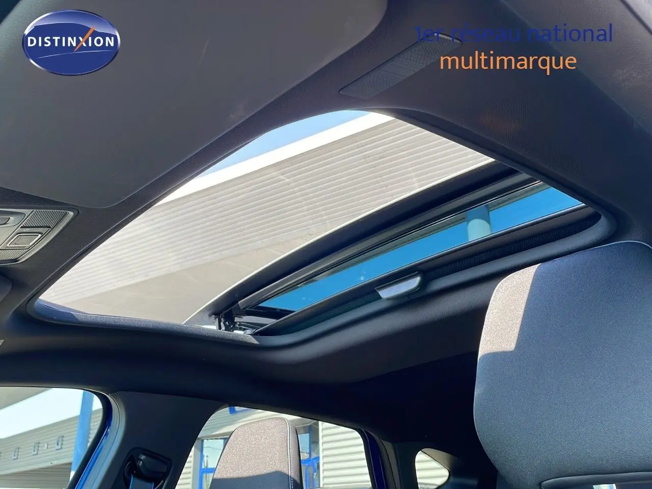Toit ouvrant panoramique ouvert sur l'intérieur du Renault Captur bleu iron metal avec toit noir, vue côté gauche.