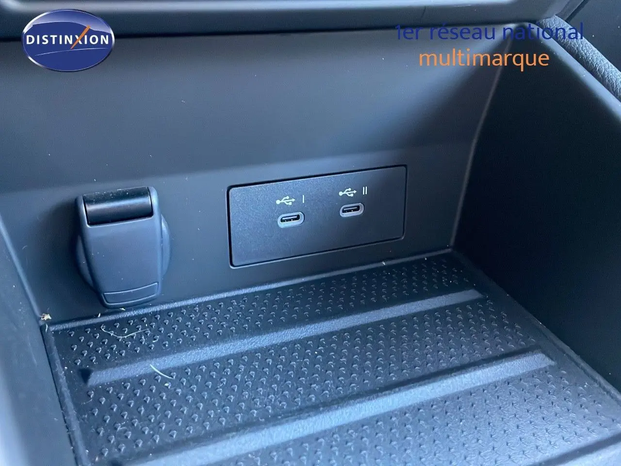 Prise USB double et prise 12V dans le compartiment de rangement avant d'un Renault Captur bleu iron metal toit noir.