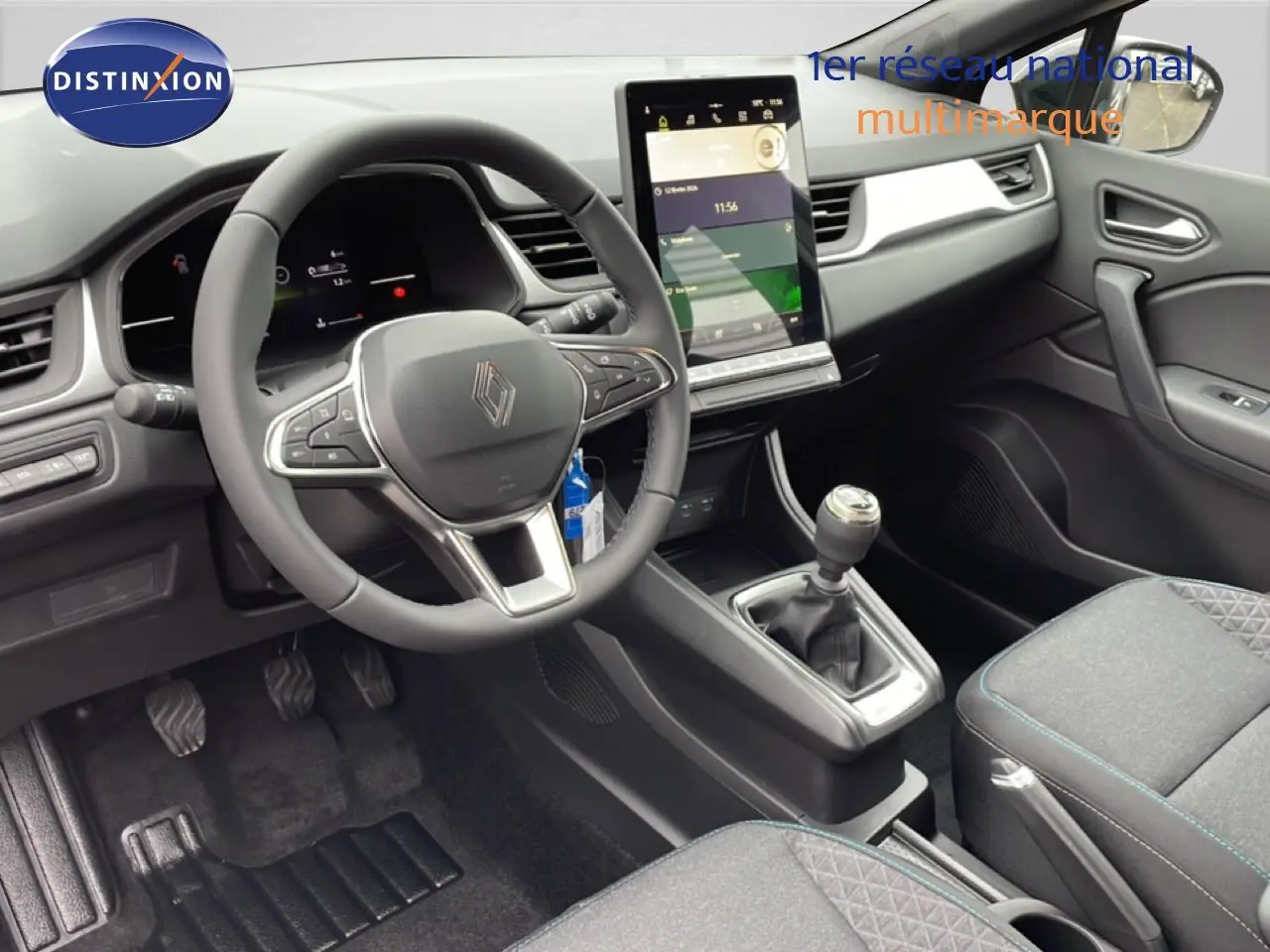 Vue intérieure du poste de conduite du Renault Captur noir étoile métal 2025, avec volant multifonction et écran tactile vertical.