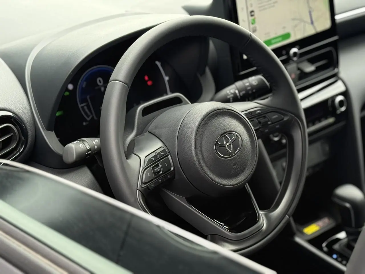Vue rapprochée du volant en cuir et du tableau de bord numérique de la Toyota Yaris Cross 1.5 Hybrid 116 Design.