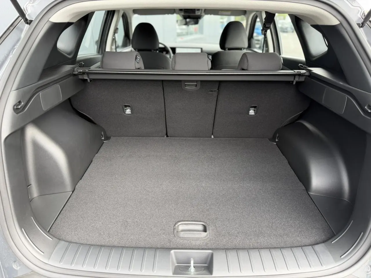 Coffre ouvert vu de l'arrière du Hyundai Tucson Ecotronic Gray 2026, montrant l'espace de chargement et la plage arrière.