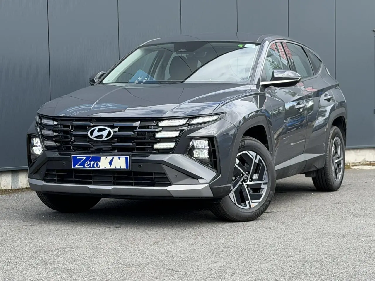 Hyundai Tucson 2026 Ecotronic Gray en 3/4 avant droit, avec calandre noire et jantes alliage 17 pouces.