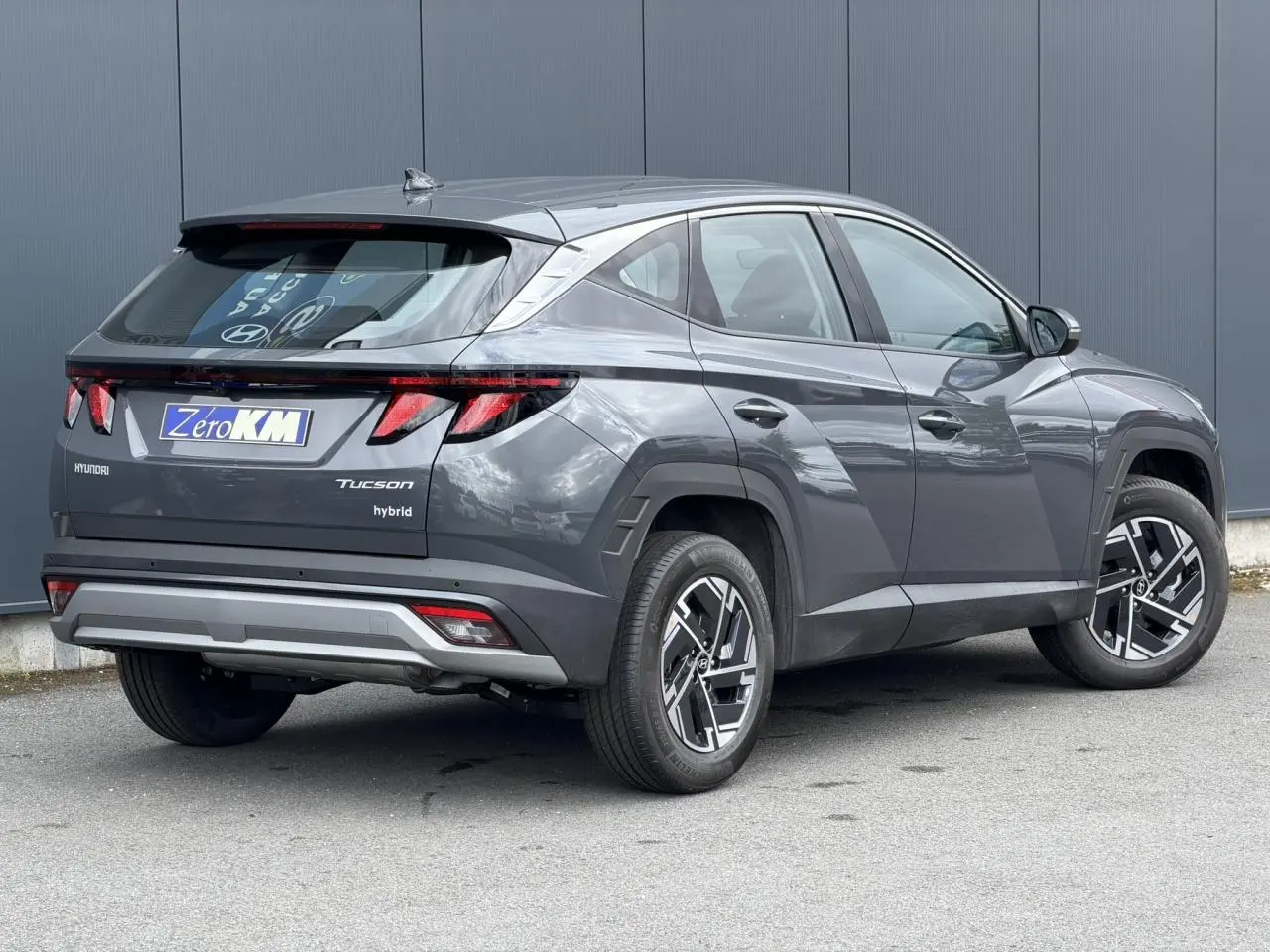 Vue 3/4 arrière droite du Hyundai Tucson 2026 Ecotronic Gray avec jantes alliage 17 pouces et antenne aileron de requin.