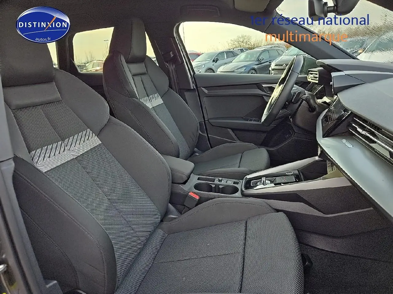 Intérieur Audi A3 Sportback 45 TFSI e 2024 vu côté conducteur, sièges sport noirs avec motifs gris et console centrale moderne.