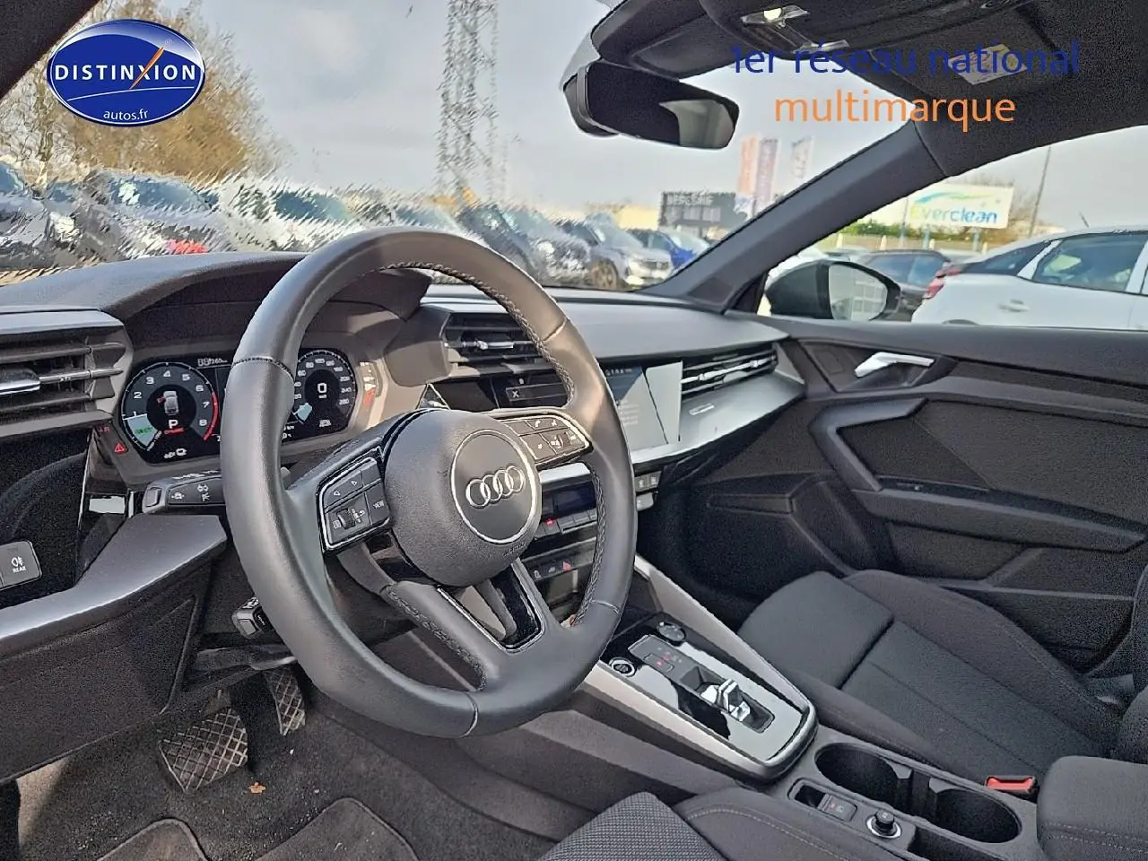 Vue intérieure côté conducteur de l'Audi A3 Sportback 45 TFSI e 2024 avec volant cuir et tableau de bord digital.