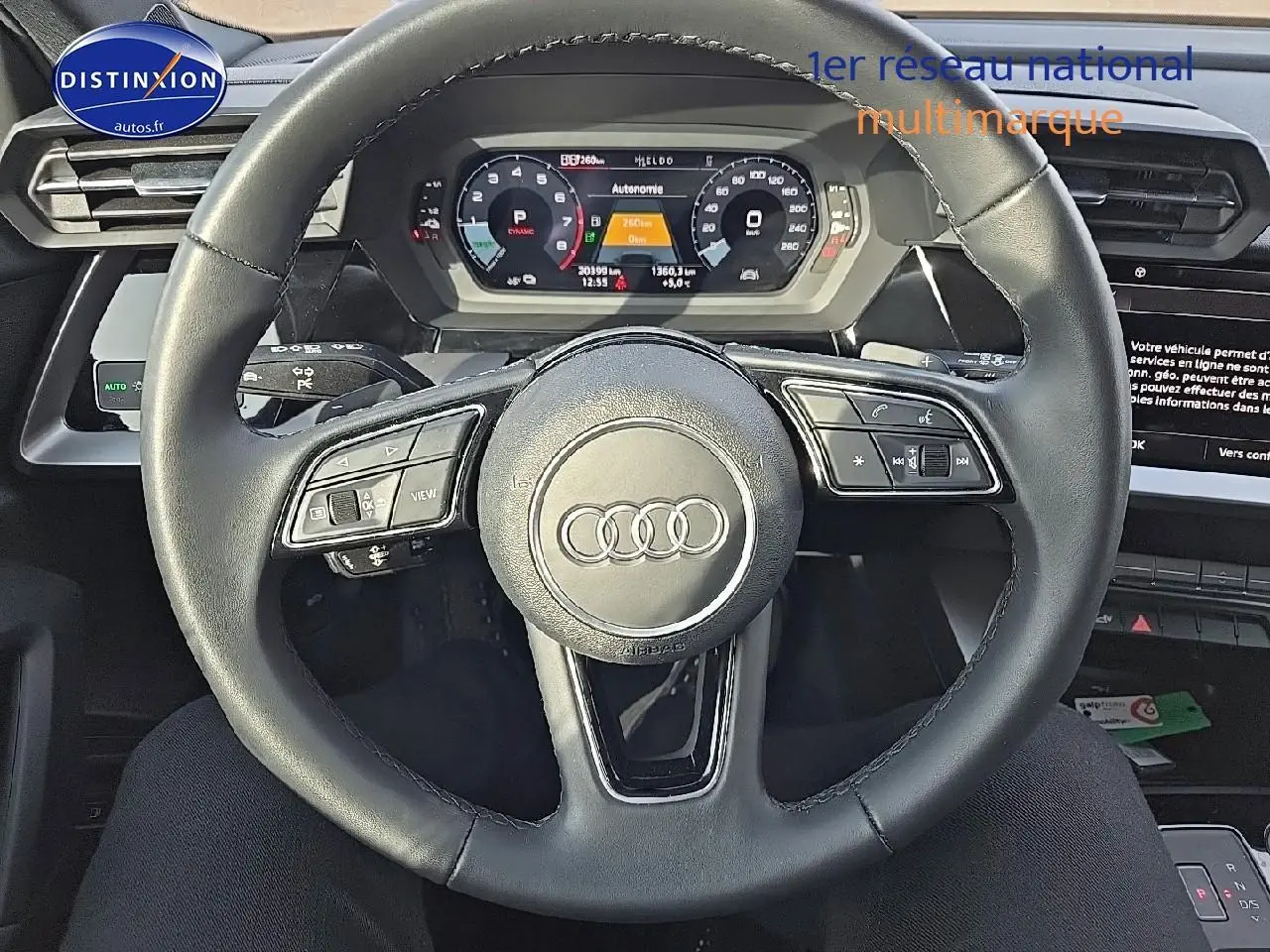 Vue centrée sur le volant cuir multifonction de l'Audi A3 Sportback 45 TFSI e gris Daytona avec tableau de bord digital.