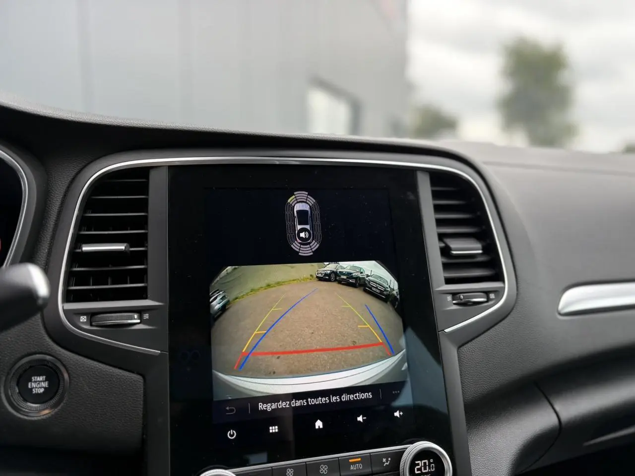 Écran tactile central affichant la caméra de recul et l'aide au stationnement du Renault Mégane Break gris Highland 2024.