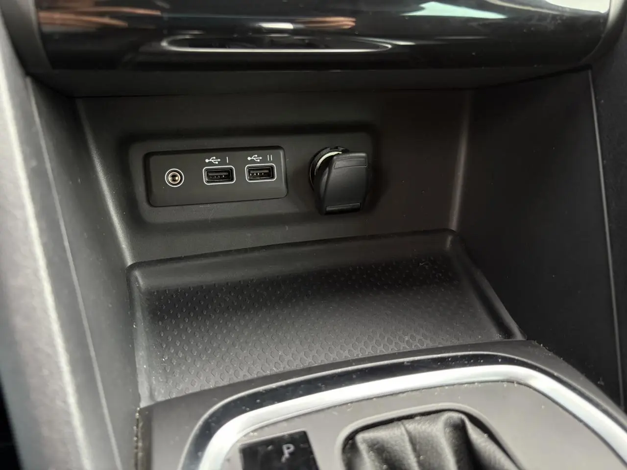 Prise USB double et allume-cigare dans la console centrale d'une Renault Mégane Break 2024 gris Highland.