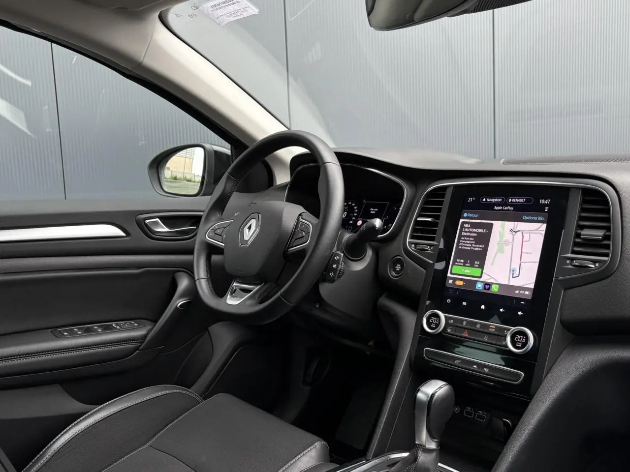 Intérieur avant gauche de Renault Mégane Break 2024 avec tableau de bord numérique et écran tactile GPS EasyLink.