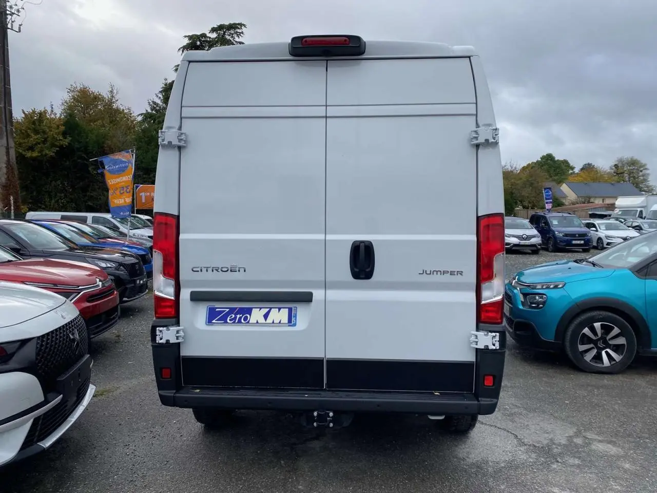 Vue arrière d'un utilitaire Citroën Jumper blanc 2025 avec portes battantes et crochet d'attelage visible.