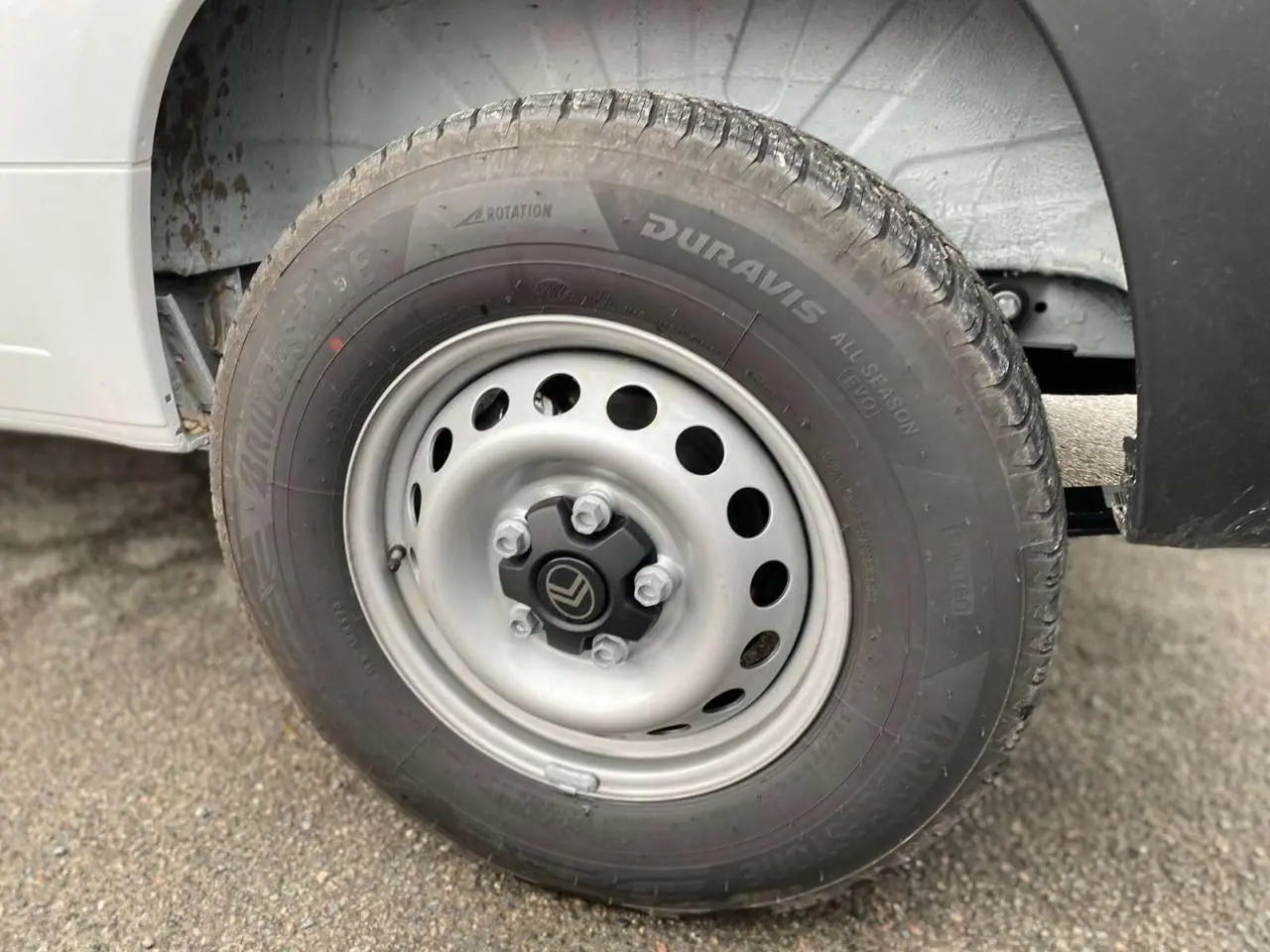 Gros plan sur la roue avant droite blanche du Citroën Jumper avec jante acier et logo Citroën au centre.