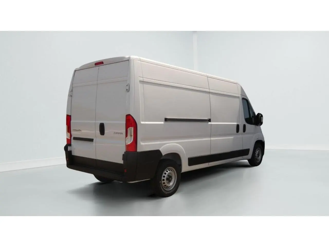 Vue 3/4 arrière droite d’un utilitaire Citroën Jumper blanc avec porte latérale coulissante et crochet d’attelage.