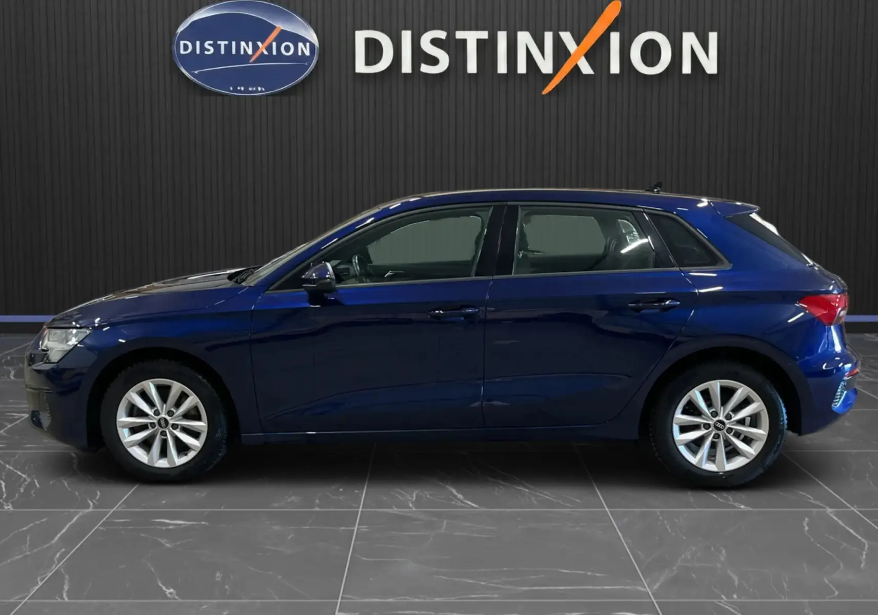 Audi A3 Sportback bleu métallisé vue de profil côté gauche, avec jantes alliage et cinq portes visibles.