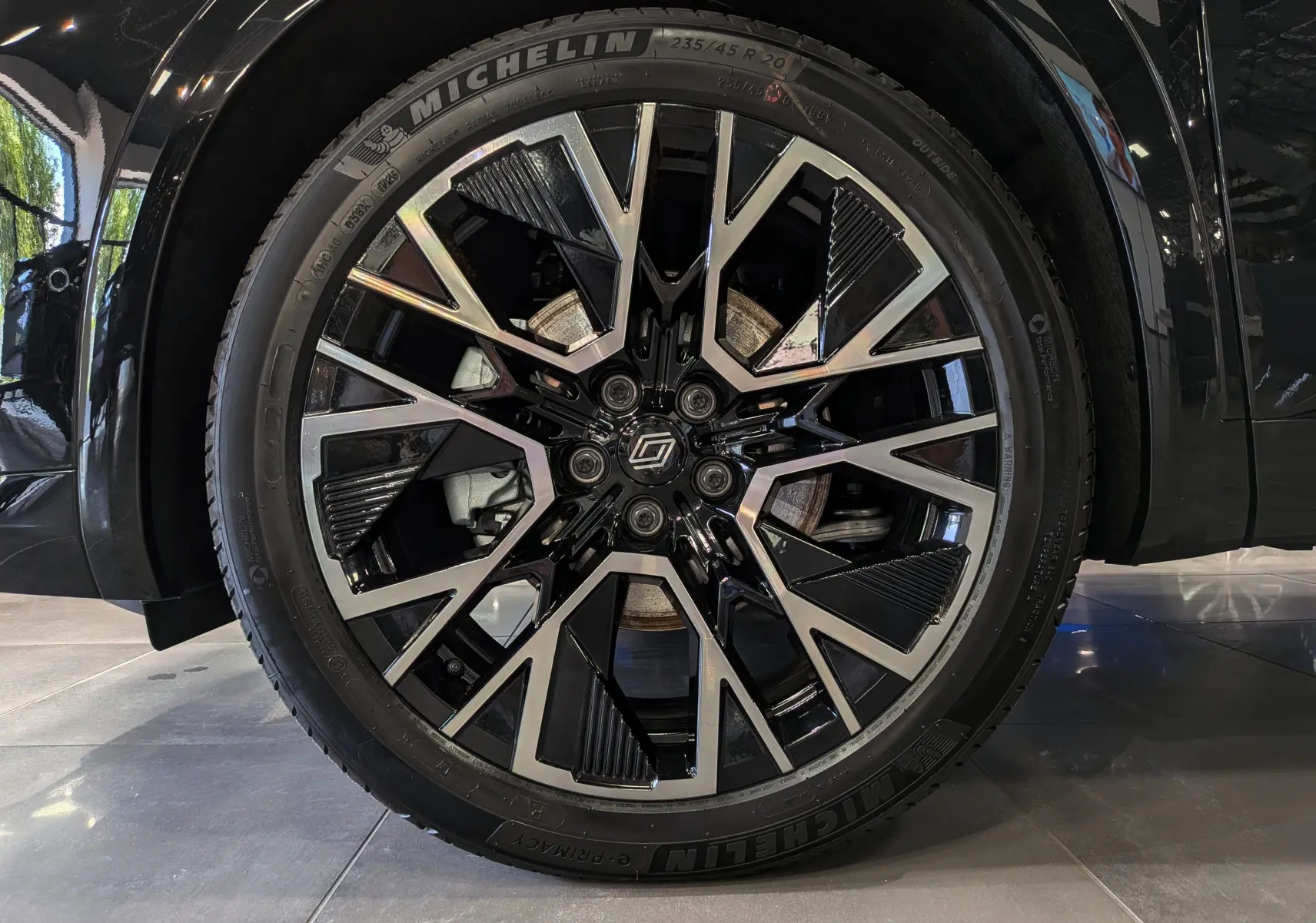 Gros plan sur la roue avant gauche noire du Renault Austral 2026 avec jante alliage bicolore et pneu Michelin.
