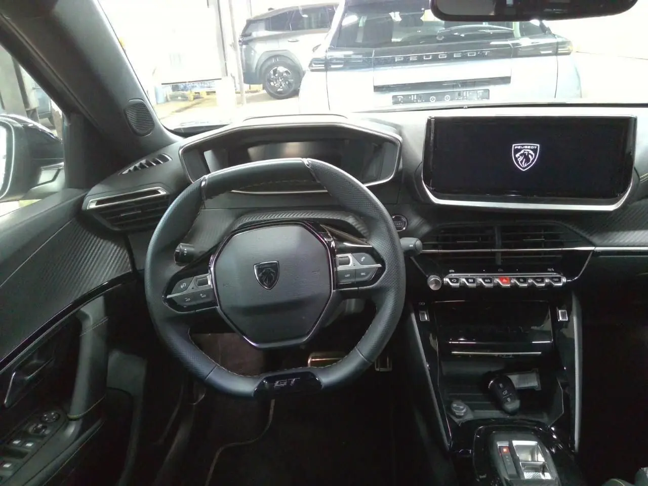 Vue intérieure centrée sur le volant GT et l’écran tactile du tableau de bord du Peugeot 2008 gris Selenium.