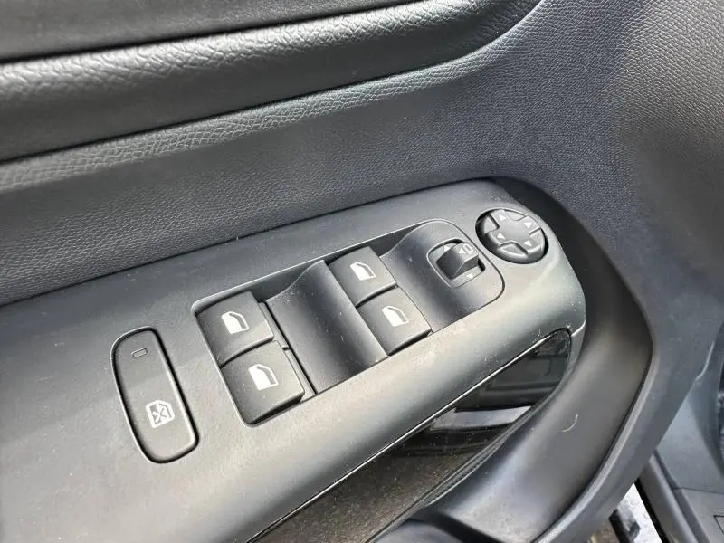 Gros plan sur les commandes de lève-vitres et rétroviseurs côté conducteur du Citroën C5 Aircross noir Perla Nera 2025.