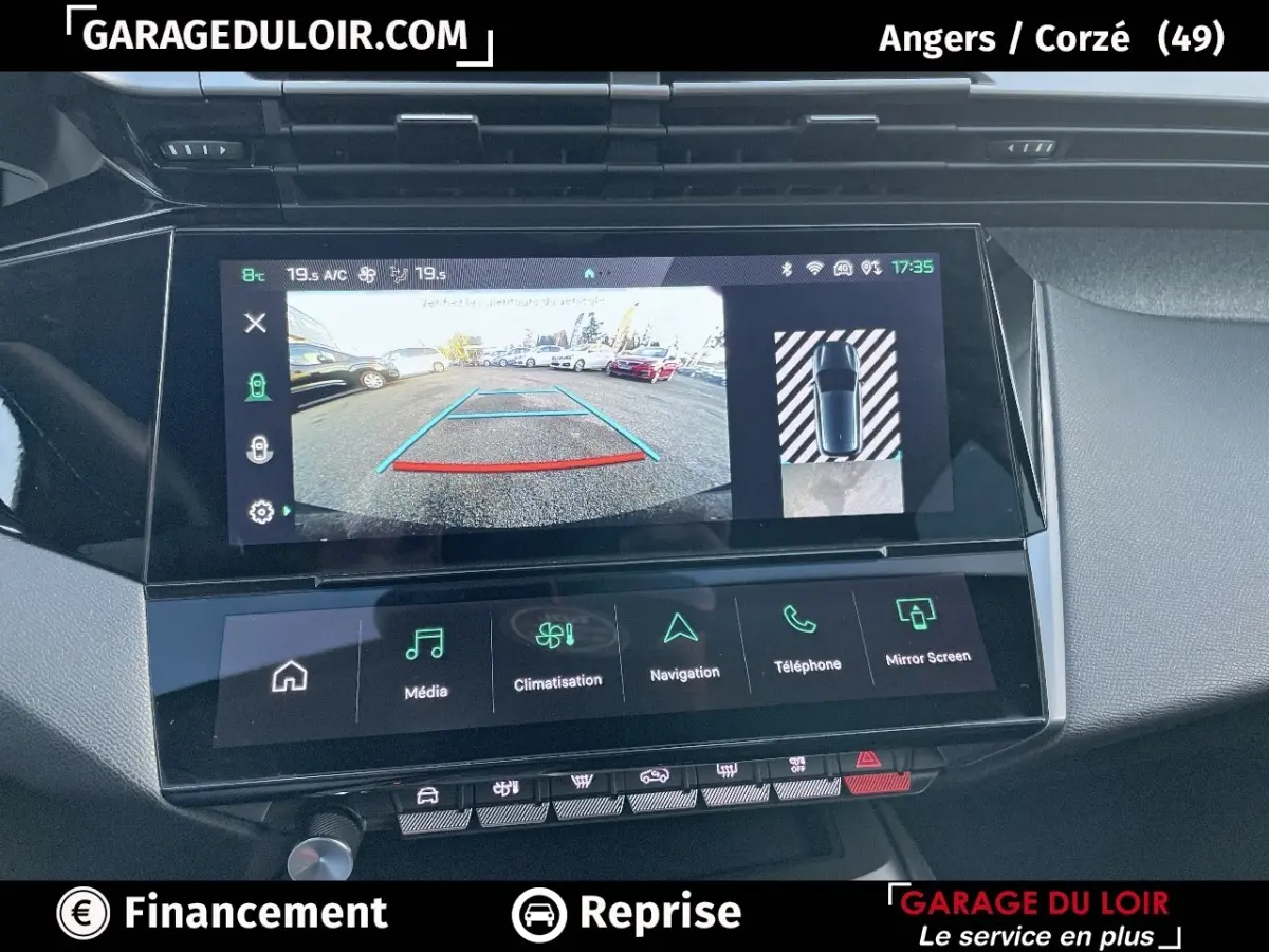 Écran tactile central de la Peugeot 308 2024 gris foncé montrant la caméra de recul et les options multimédia en intérieur.