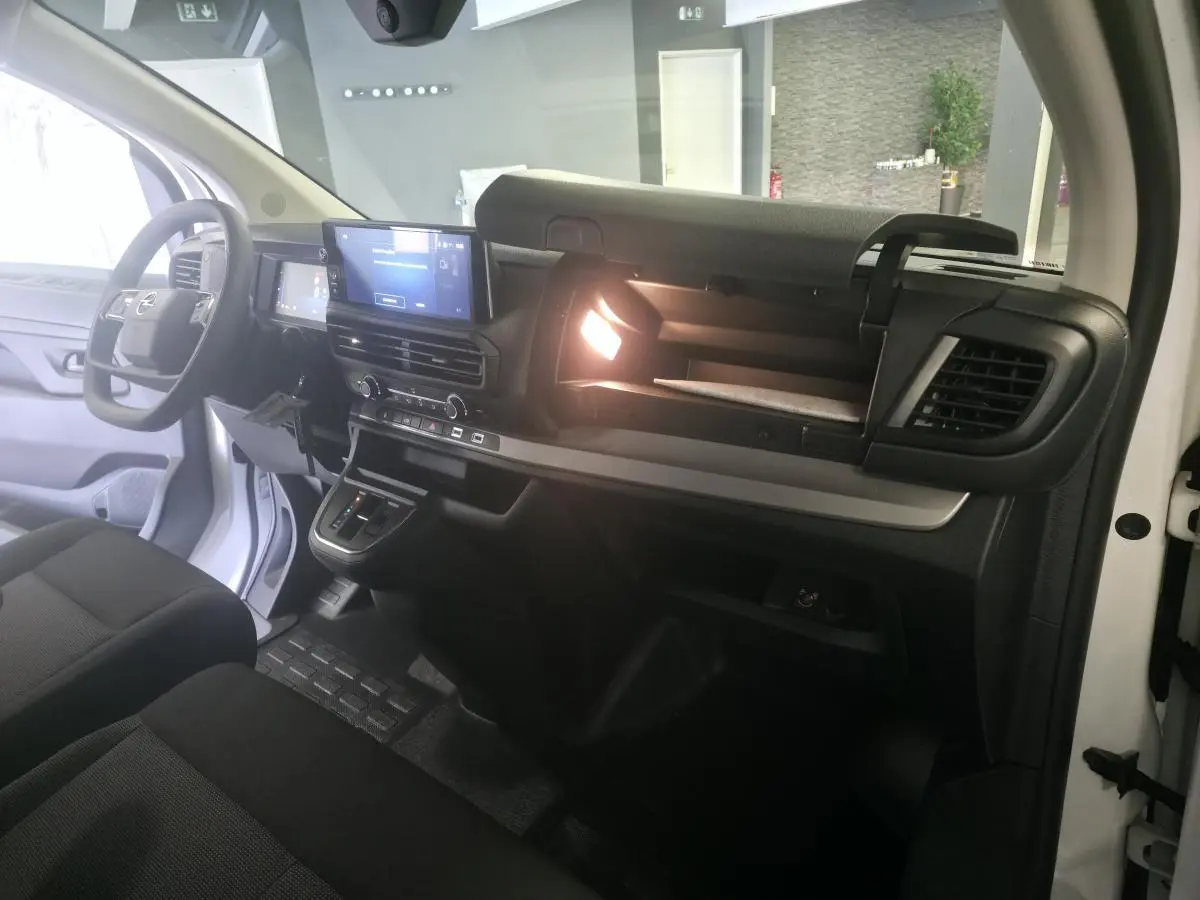 Vue intérieure côté passager de l'Opel Vivaro blanc 2025, tableau de bord avec écran tactile 10'' et boîte auto.
