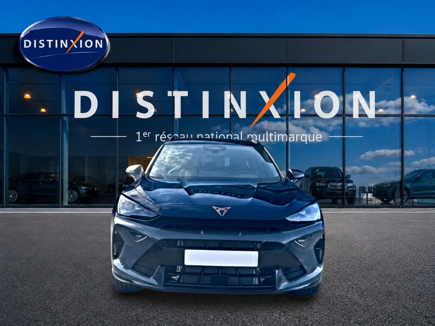 Vue frontale du CUPRA Formentor bleu fjord 2026 avec logo distinctif et calandre sportive devant un showroom Distinxion.