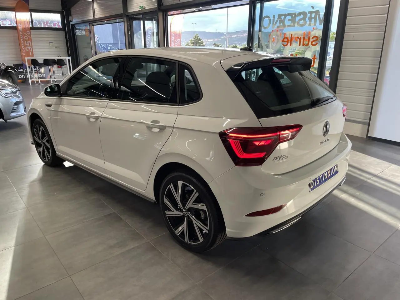 Vue 3/4 arrière droite de la Volkswagen Polo blanche 2024 R-Line avec jantes alliage et feux LED distinctifs.