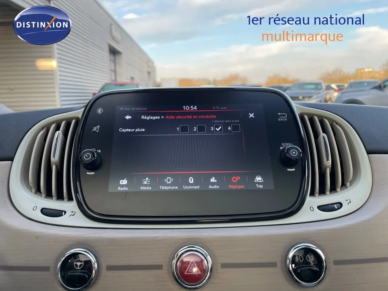 Écran tactile central avec réglages d'aide à la conduite dans l'habitacle clair d'une Fiat 500 blanche 2022.