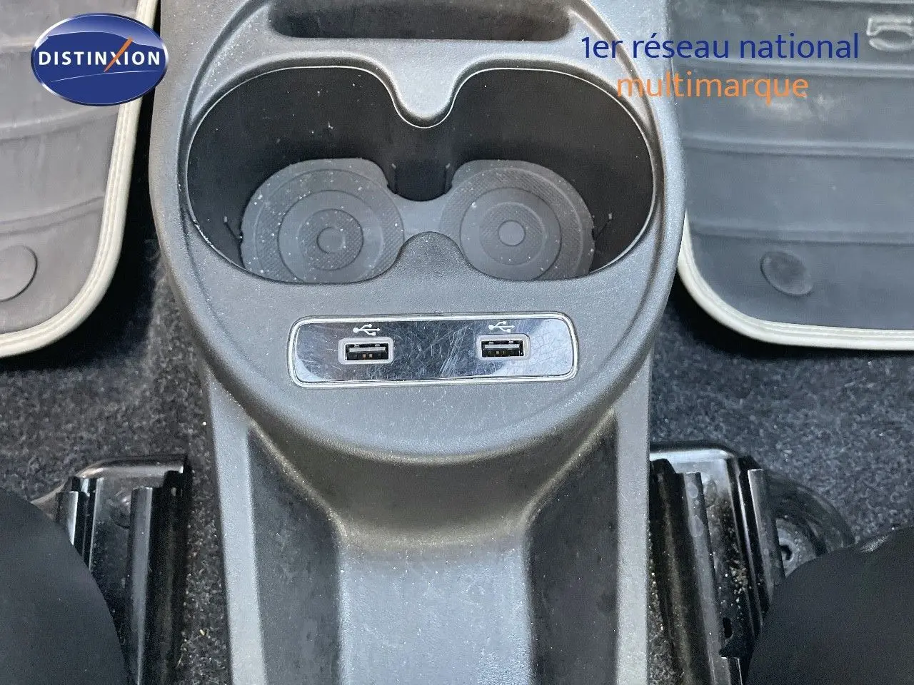 Gros plan sur la console centrale avec porte-gobelets et deux ports USB de la FIAT 500 blanche 1.0 Hybrid 2022.