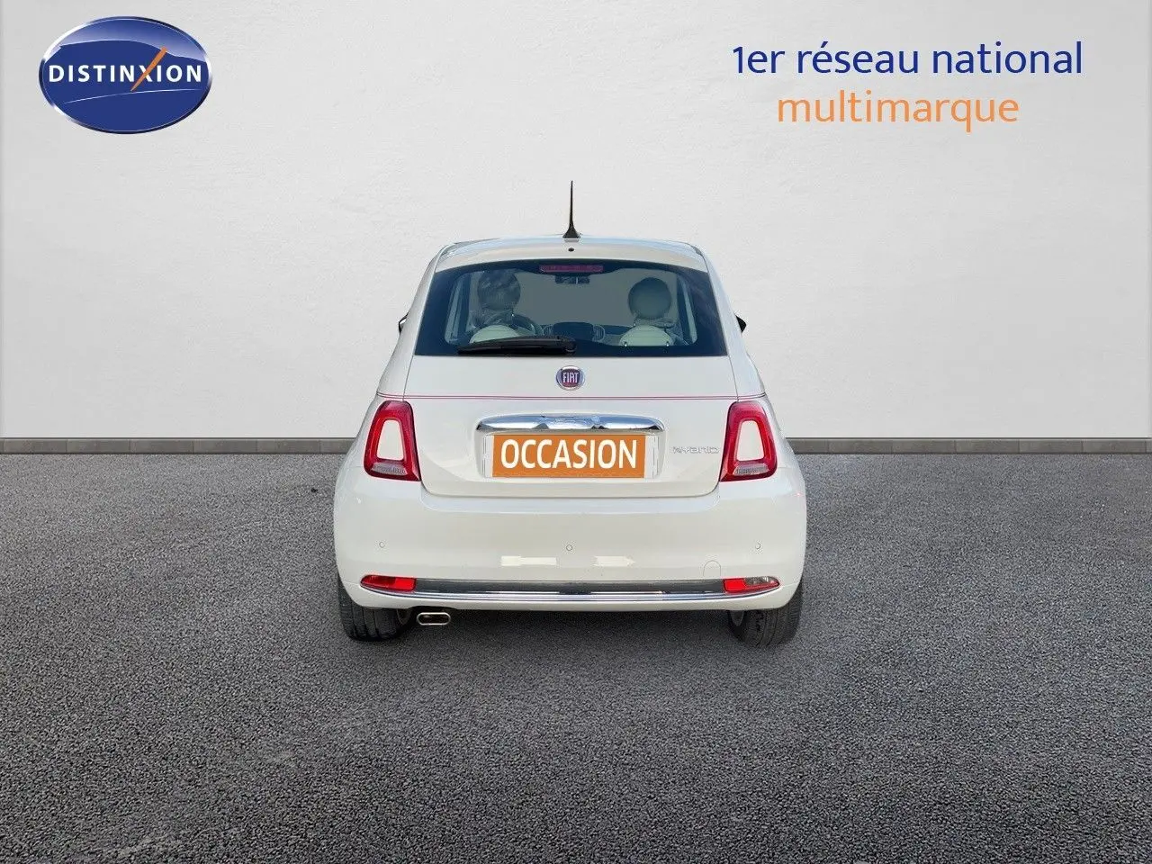 Vue arrière d'une FIAT 500 blanche 1.0 Hybrid 70ch DolceVita de 2022 avec plaque "OCCASION" sur un sol gris.
