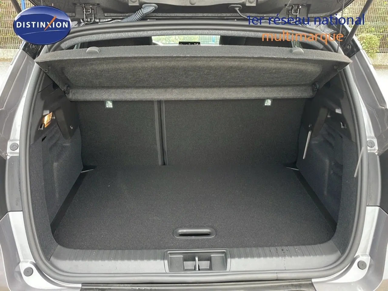 Coffre ouvert du Renault Captur E-Tech Hybrid 2025 gris Cassiopée métal avec toit noir, vue arrière détaillée.