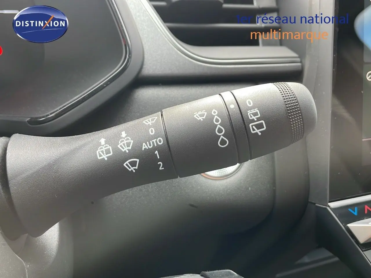 Gros plan sur la commande des essuie-glaces du tableau de bord d'un Renault Captur gris Cassiopée métal toit noir 2025.