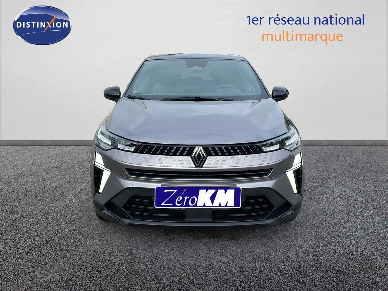 Vue frontale d'un Renault Captur E-Tech Hybrid 2025 gris cassiopée avec toit noir et feux LED allumés.