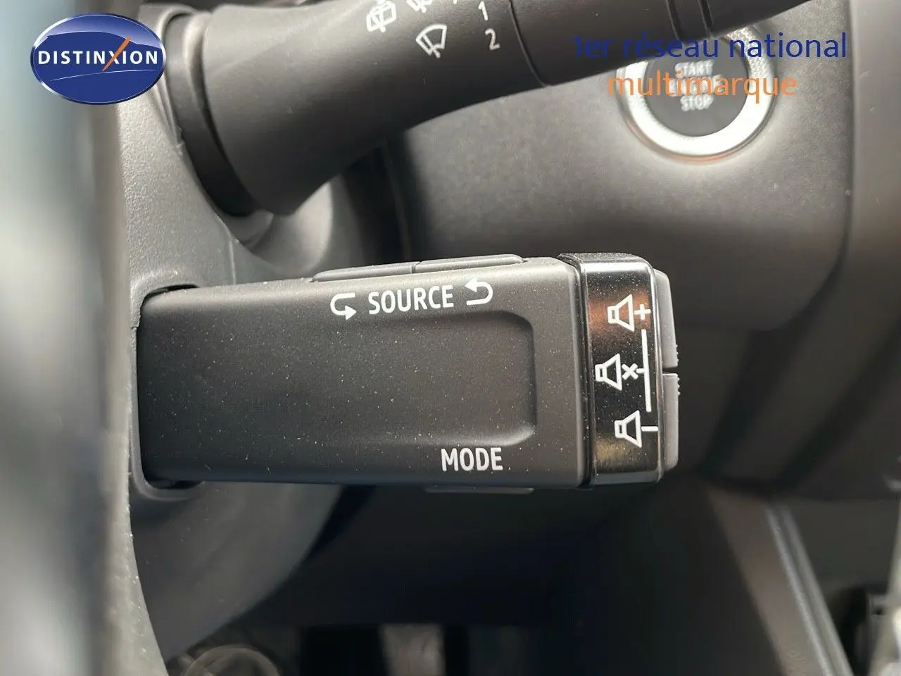 Gros plan sur la commande de source audio et mode du Renault Captur E-Tech gris Cassiopée avec toit noir, intérieur noir.