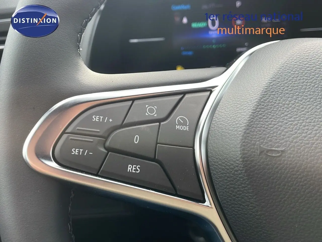 Gros plan sur les commandes de régulateur de vitesse au volant du Renault Captur E-Tech hybride gris Cassiopée toit noir.