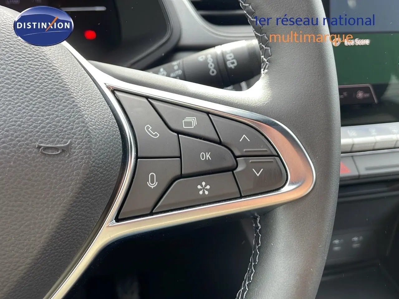 Gros plan sur les commandes au volant du Renault Captur E-Tech hybride 2025, intérieur noir avec détails argentés.