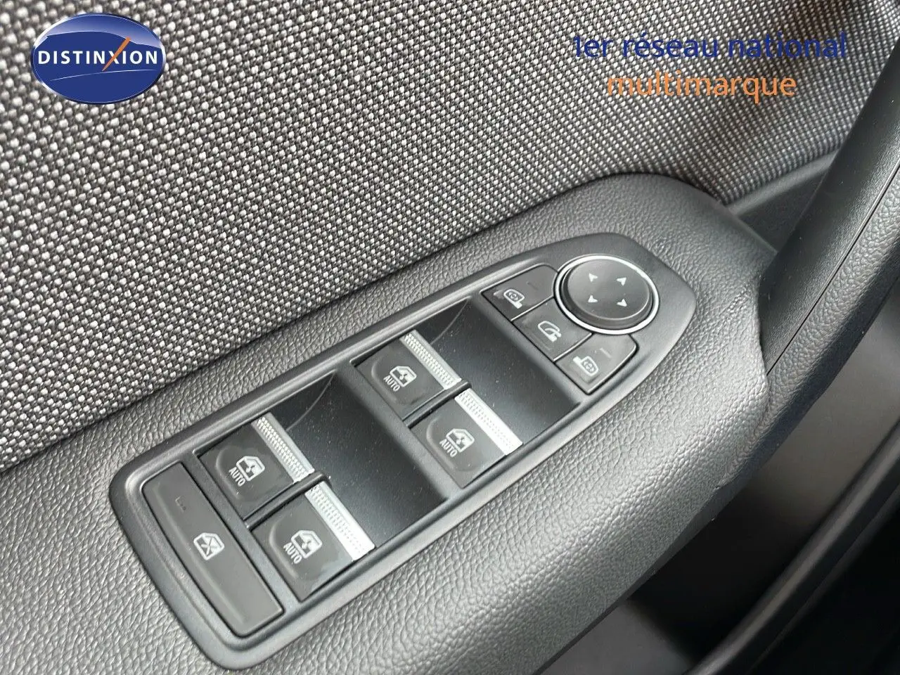 Gros plan sur les commandes de lève-vitres et rétroviseurs côté conducteur du Renault Captur gris cassiopée 2025.