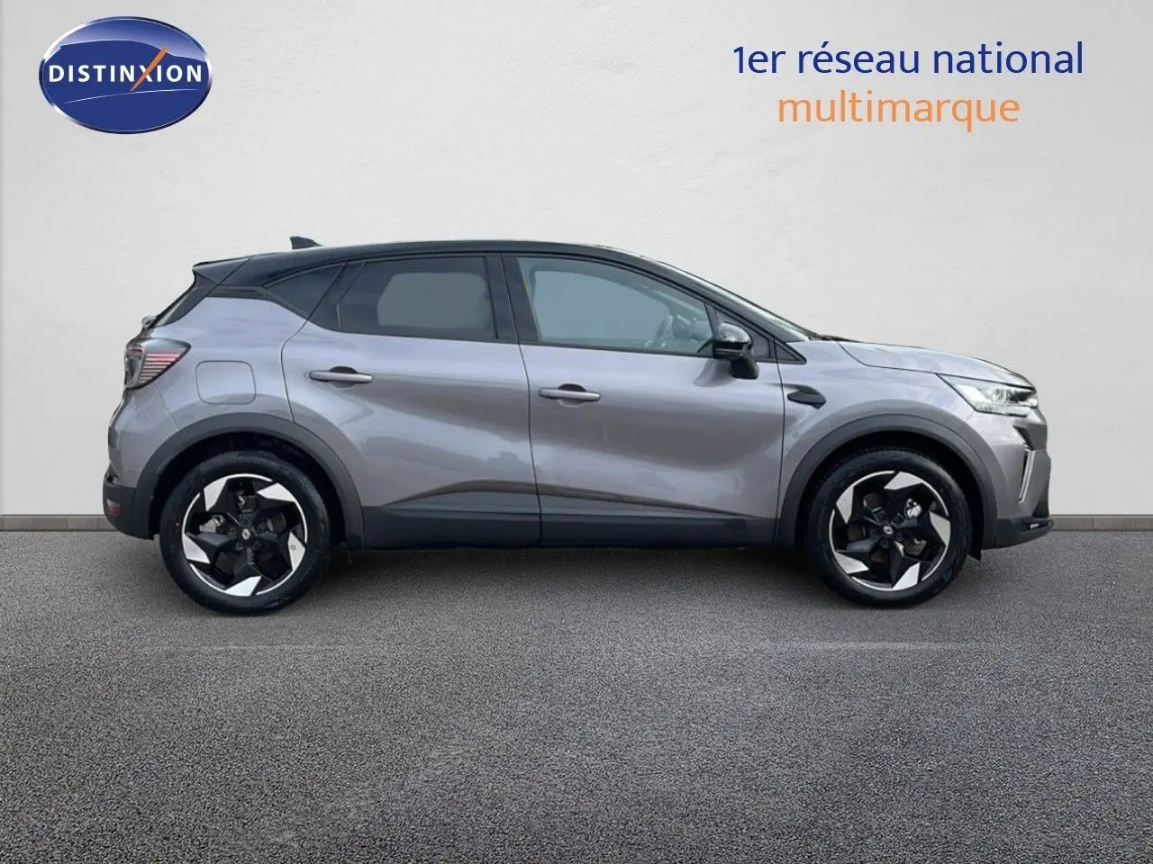 Profil droit du Renault Captur E-Tech hybride gris Cassiopée avec toit noir et jantes 18 pouces bicolores.
