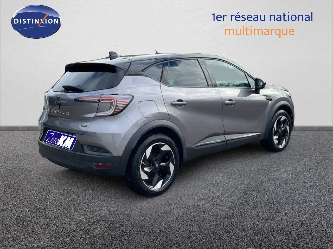 Vue 3/4 arrière droite du Renault Captur E-Tech gris Cassiopée avec toit noir et jantes bicolores.