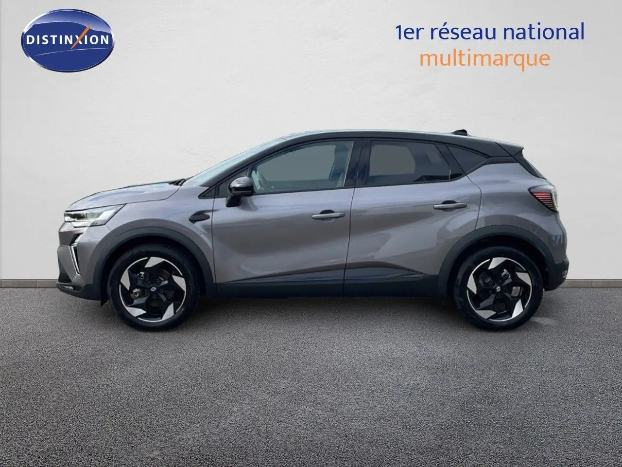 Profil côté gauche du Renault Captur E-Tech F.Hybrid 2025 gris Cassiopée métal avec toit noir et jantes bicolores.