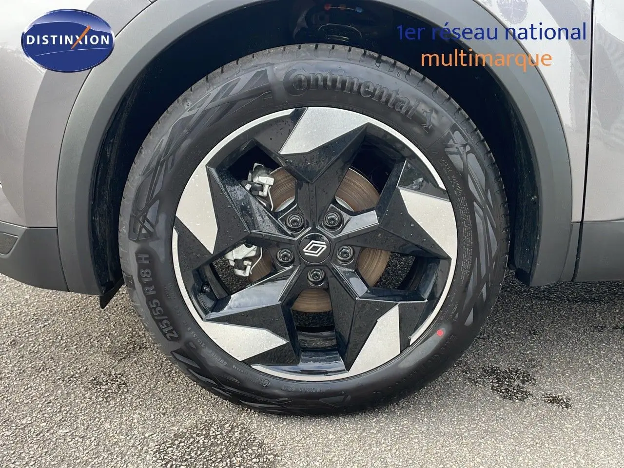Gros plan sur la roue avant gauche du Renault Captur E-Tech gris Cassiopée avec jante noire et argentée en étoile.