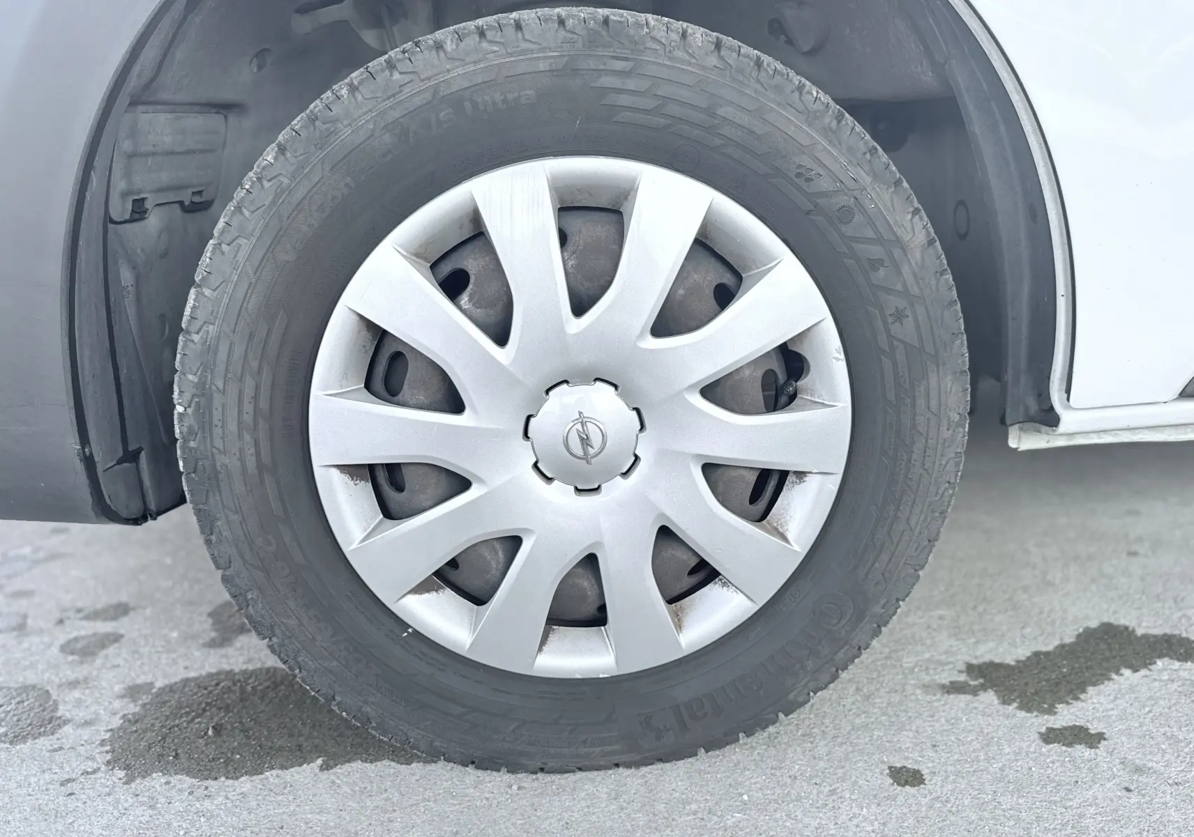 Gros plan sur la roue avant gauche blanche d’un Opel Vivaro 2018 avec enjoliveur argenté et pneu Continental.