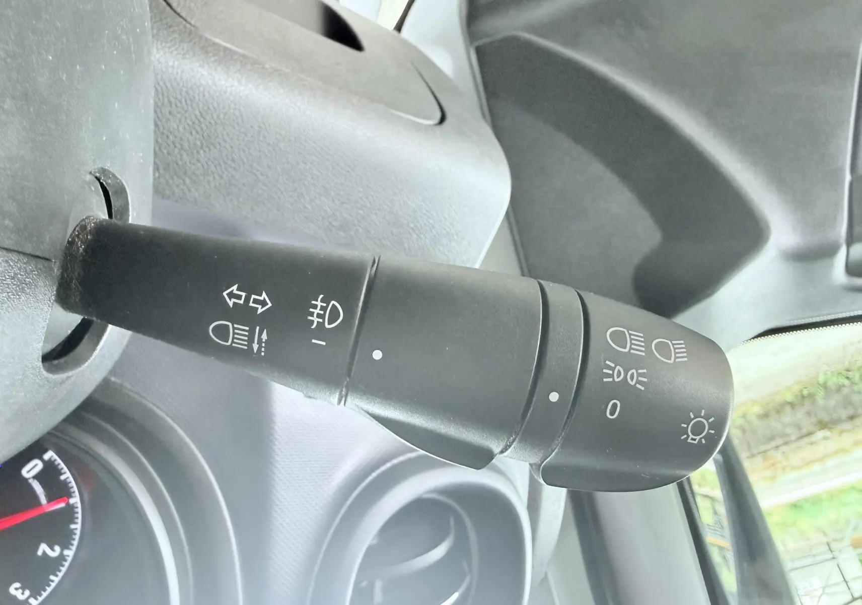 Gros plan sur la manette de commande des feux et clignotants dans l’habitacle d’un Opel Vivaro blanc de 2018.
