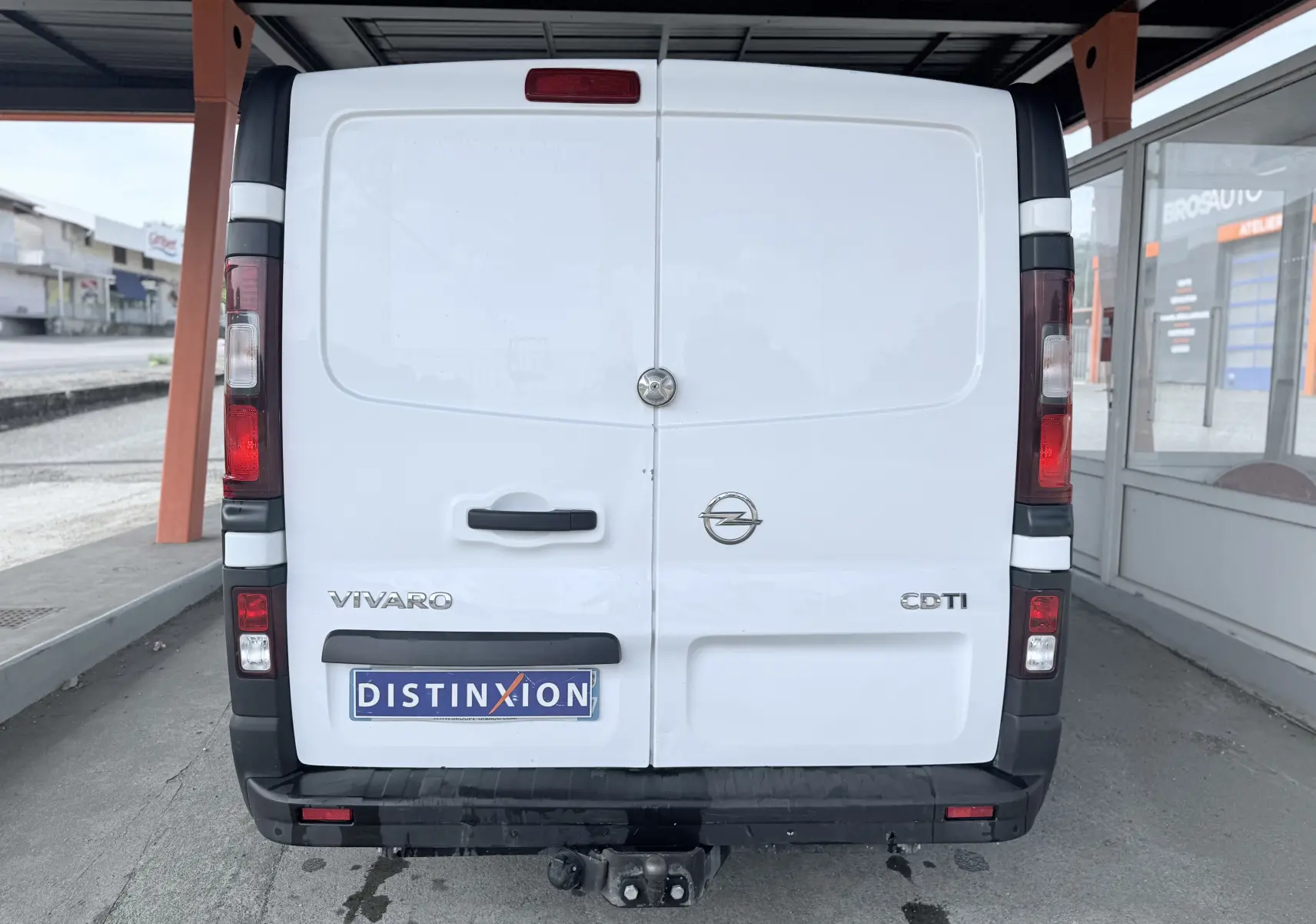 Vue arrière d’un Opel Vivaro blanc avec hayon fermé et attelage visible sous le pare-chocs noir.