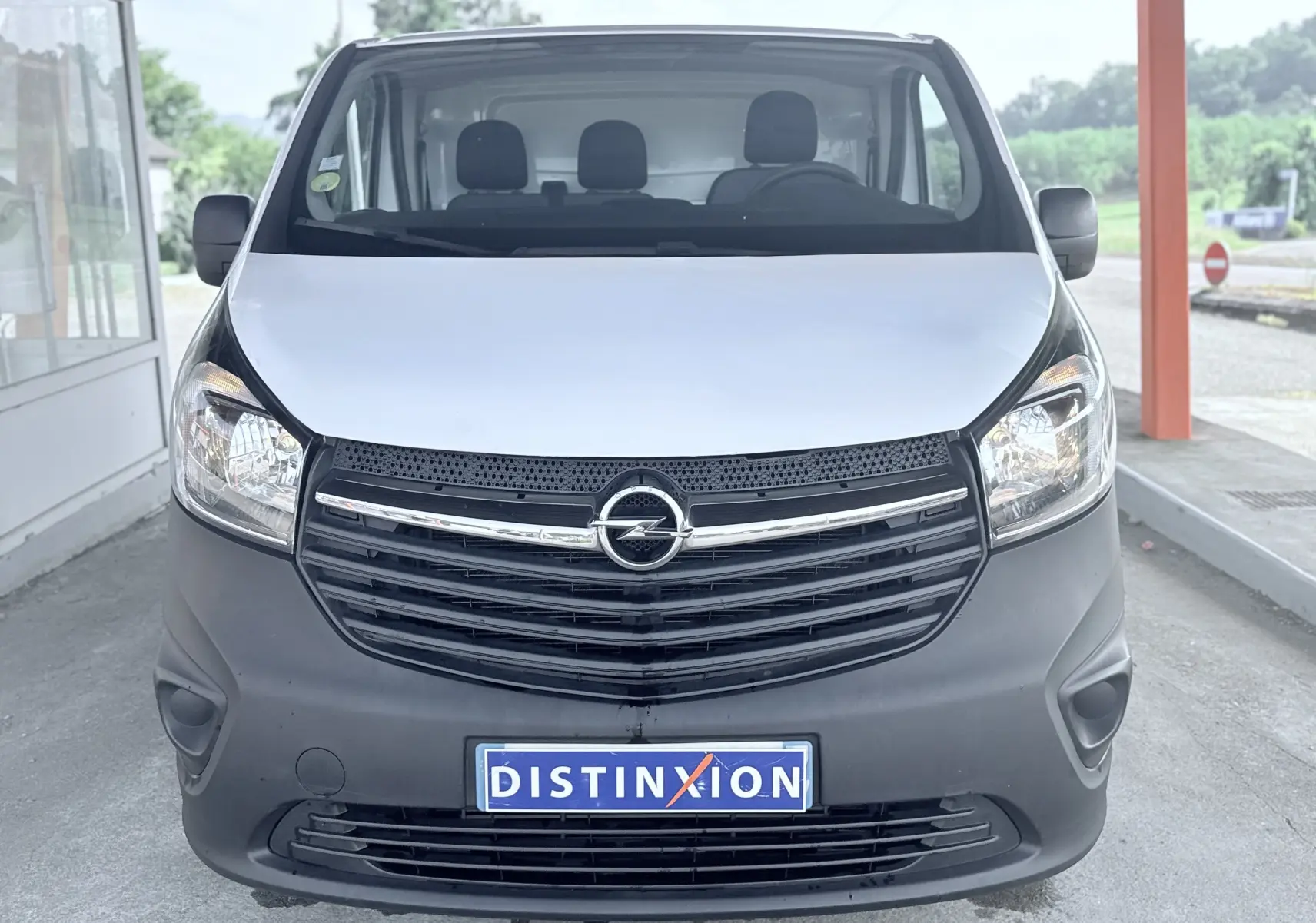 Vue avant d’un Opel Vivaro blanc avec calandre noire et plaque d’immatriculation Distinxion visible.