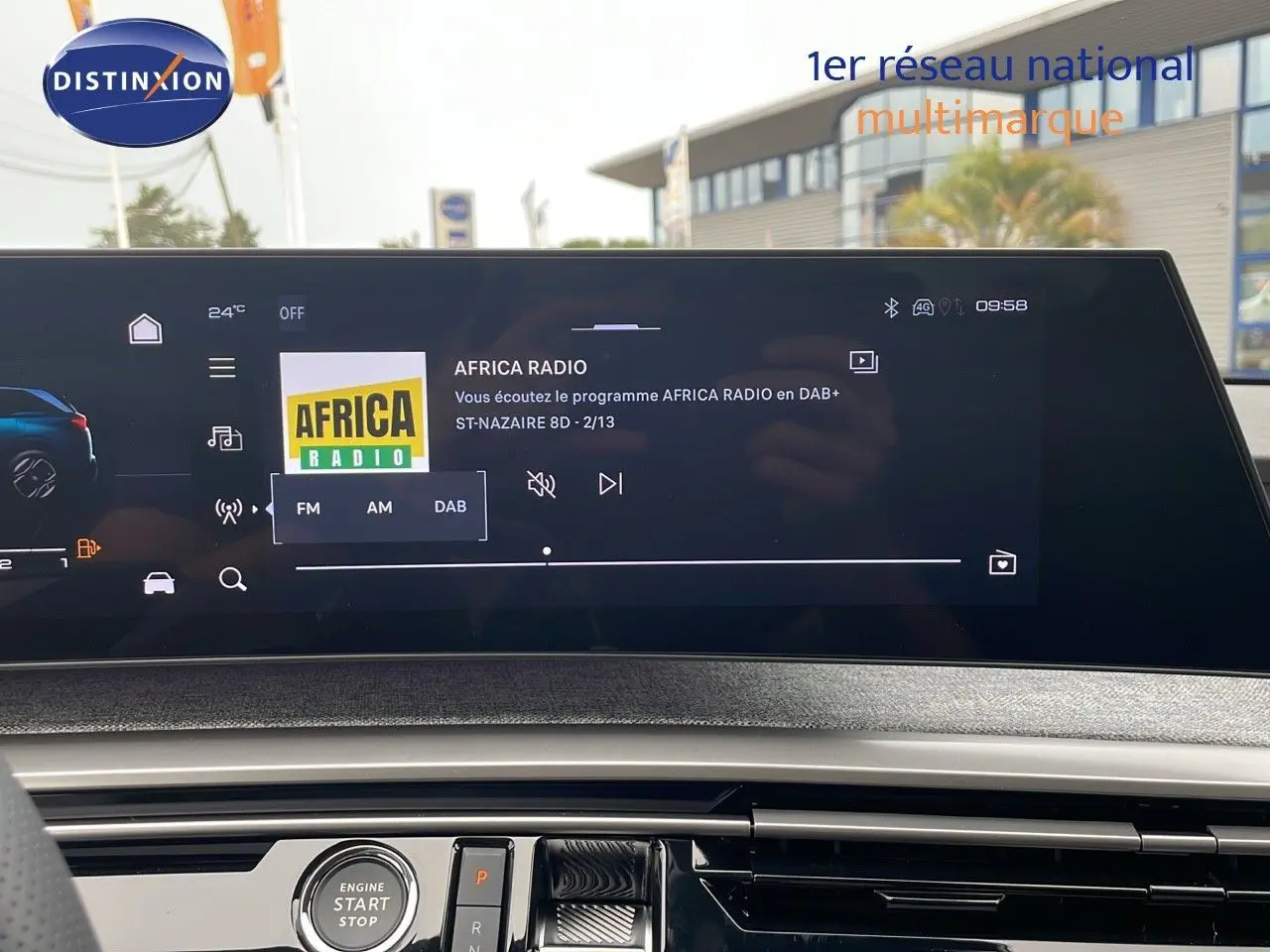 Vue intérieure du tableau de bord du Peugeot 5008 Hybrid gris Artense, écran tactile affichant Africa Radio en DAB