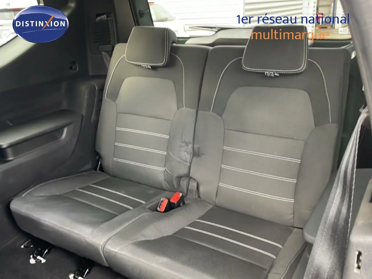 Vue intérieure sur la banquette arrière en tissu noir avec surpiqûres blanches du Dacia Jogger 2025.