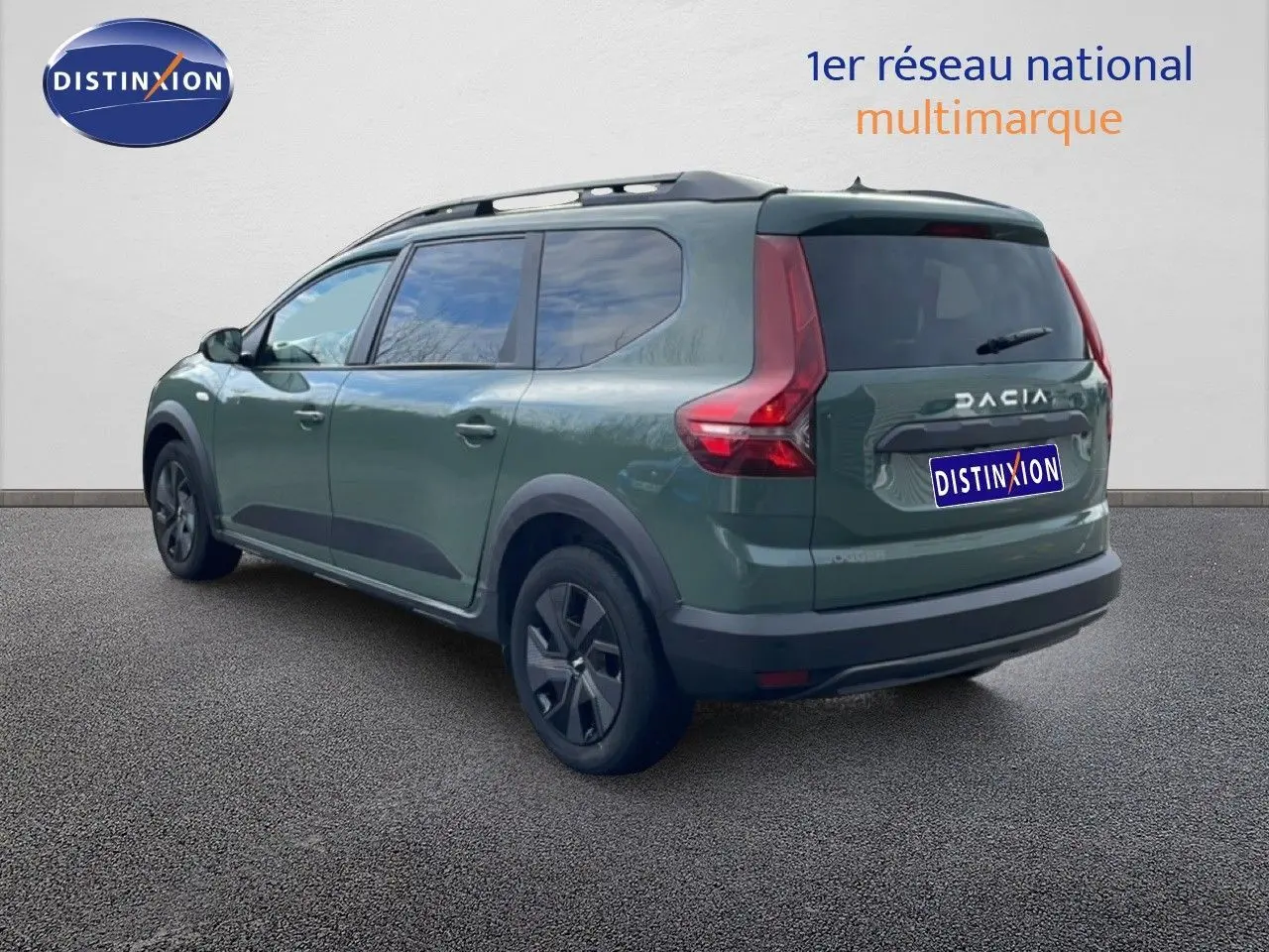 Vue 3/4 arrière gauche d'un Dacia Jogger 2025 kaki lichen avec barres de toit et jantes noires.